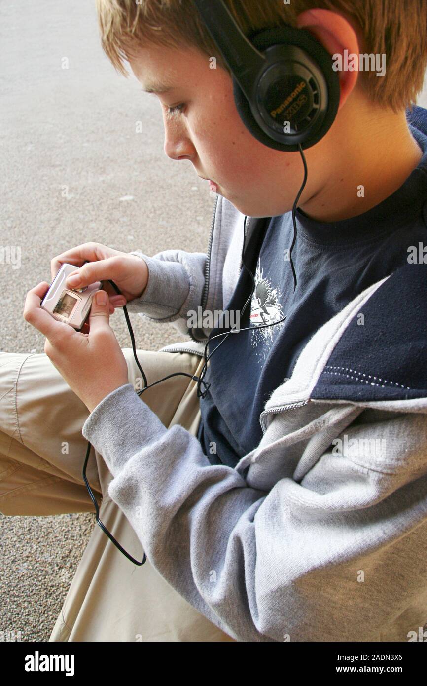 Modello rilasciato. Lettore MP3 utilizzare. Ragazzo con le cuffie per  ascoltare un lettore MP3 Foto stock - Alamy