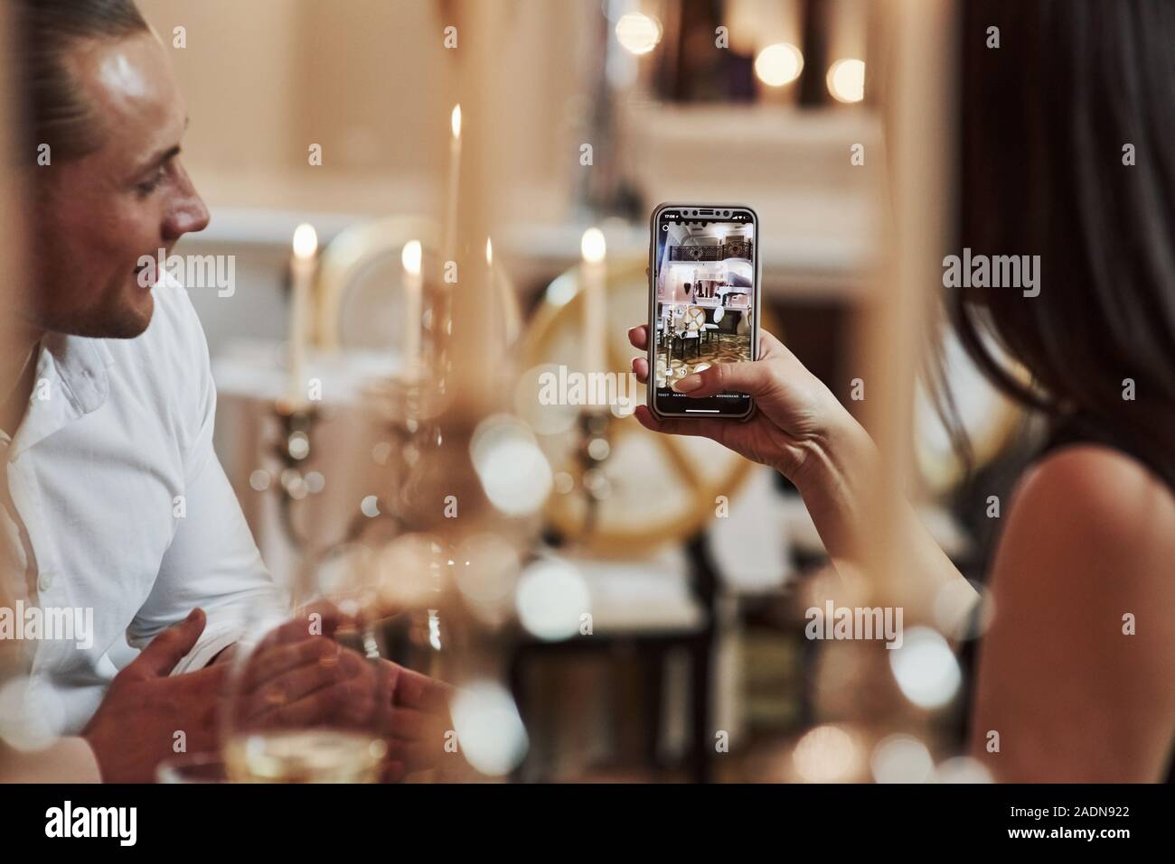 Ragazzina prende la foto del pianista. Bella giovane hanno una romantica cena in ristorante di lusso al tempo della sera Foto Stock