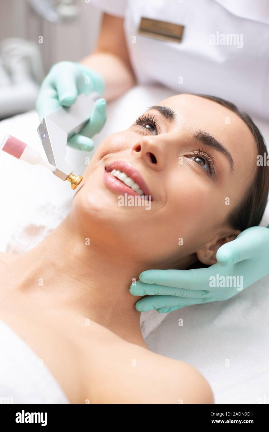 Cool ossigeno procedura di sollevamento e giovane sorride client Foto Stock
