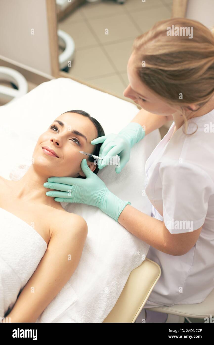 Vista superiore della donna soddisfatti di ottenere l'iniezione di acido ialuronico Foto Stock