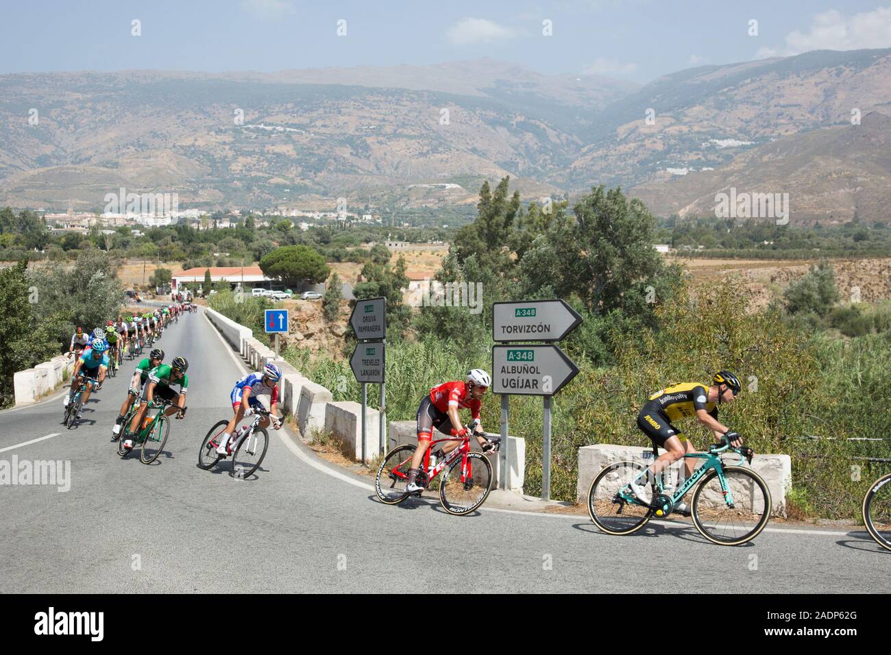 Ciclisti in gara sulla strada Vuelta de España attraversando il ponte sul fiume Guadalfeo vicino a Orgiva, Granada, Andalusia, 29 agosto 2018. Foto Stock