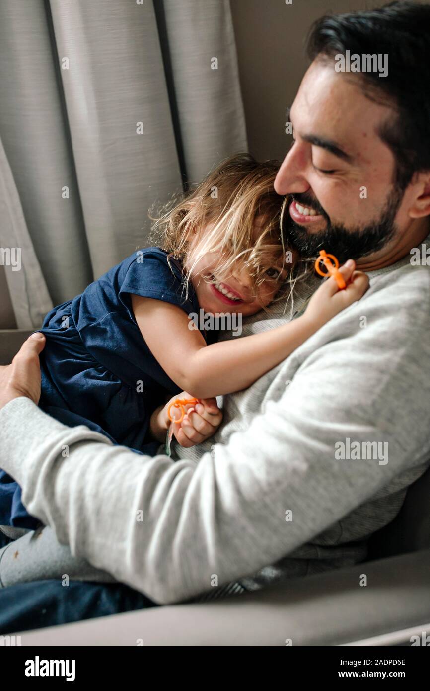 Papà sorridente con la barba cuddling con felice 4 anni figlia Foto Stock