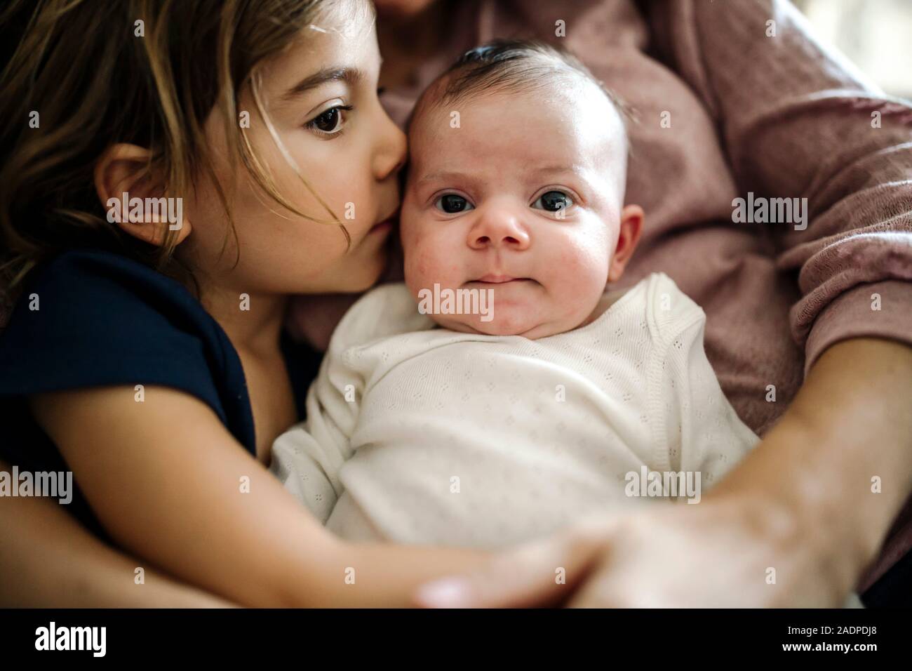 Sweet 4 yr old kissing testa della sorella per neonati Foto Stock