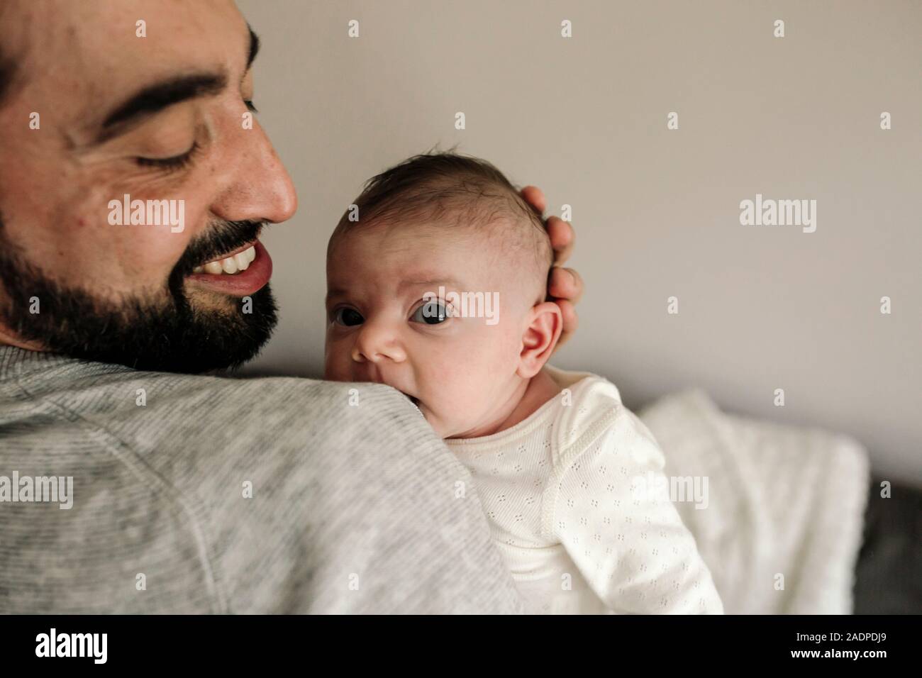 Felice papà con la barba e il bel sorriso holding neonato Foto Stock