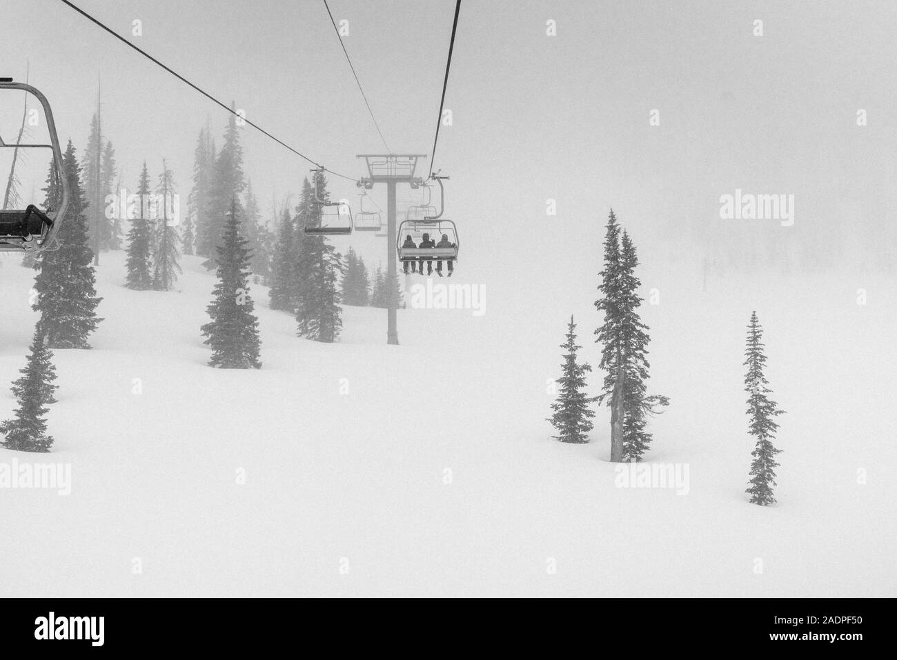 Gli sciatori con la seggiovia in blizzard Foto Stock