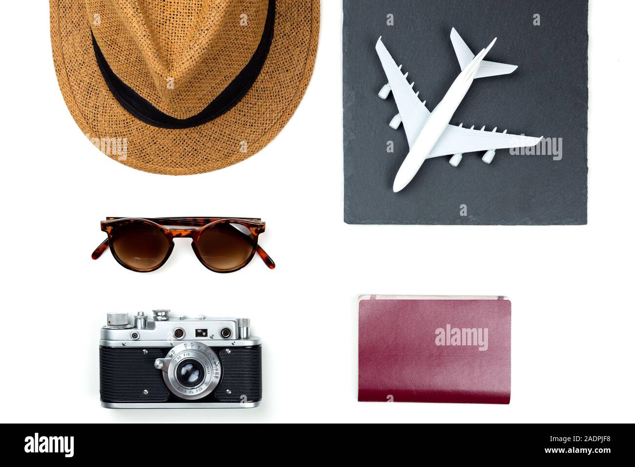 Luce viaggiano elemento accessorio, hat, aereo, occhiali da sole, fotocamera e passaporto,essentials per vacanza. concetto di viaggio sullo sfondo Foto Stock