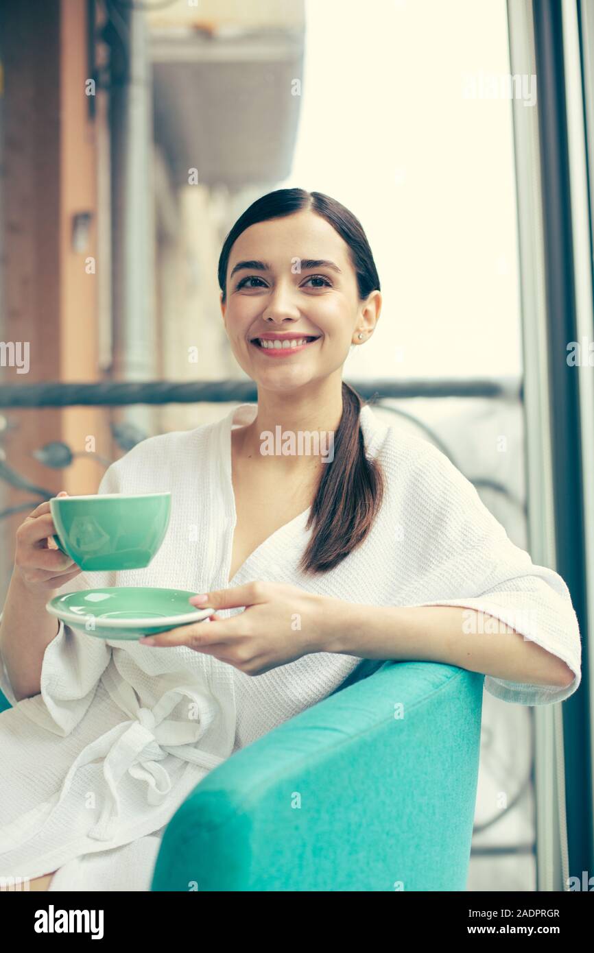Capelli lunghi signora sorridente e gustare deliziosi tè Foto Stock