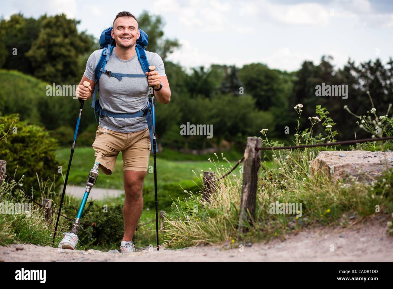 Overjoyed giovane con protesi cercando Nordic walking Foto Stock