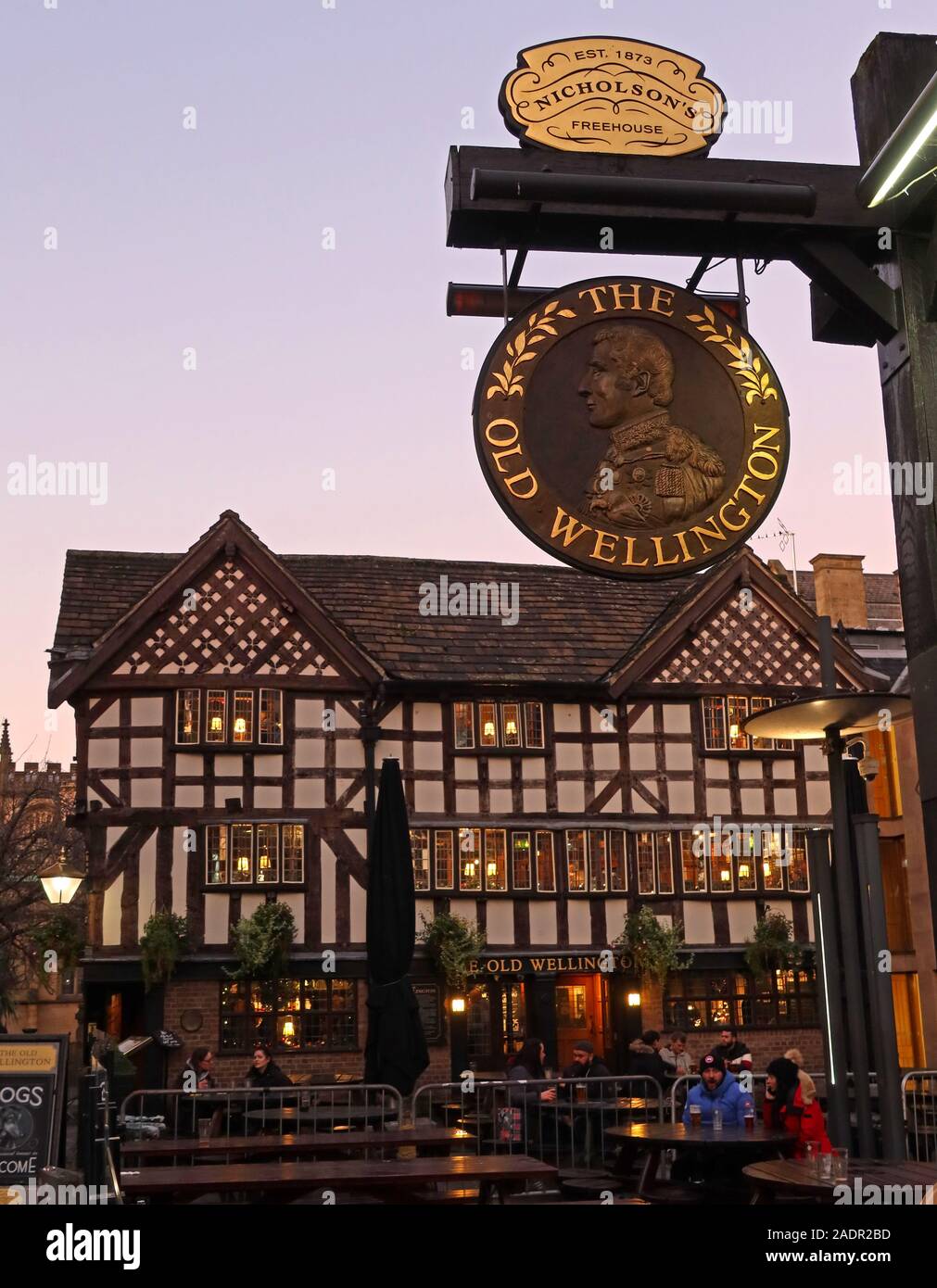 The Old Wellington, a graticcio, pub dal 1552, monumento antico programmato, 4 Cathedral Gates, Manchester. Al tramonto, in inverno. Foto Stock