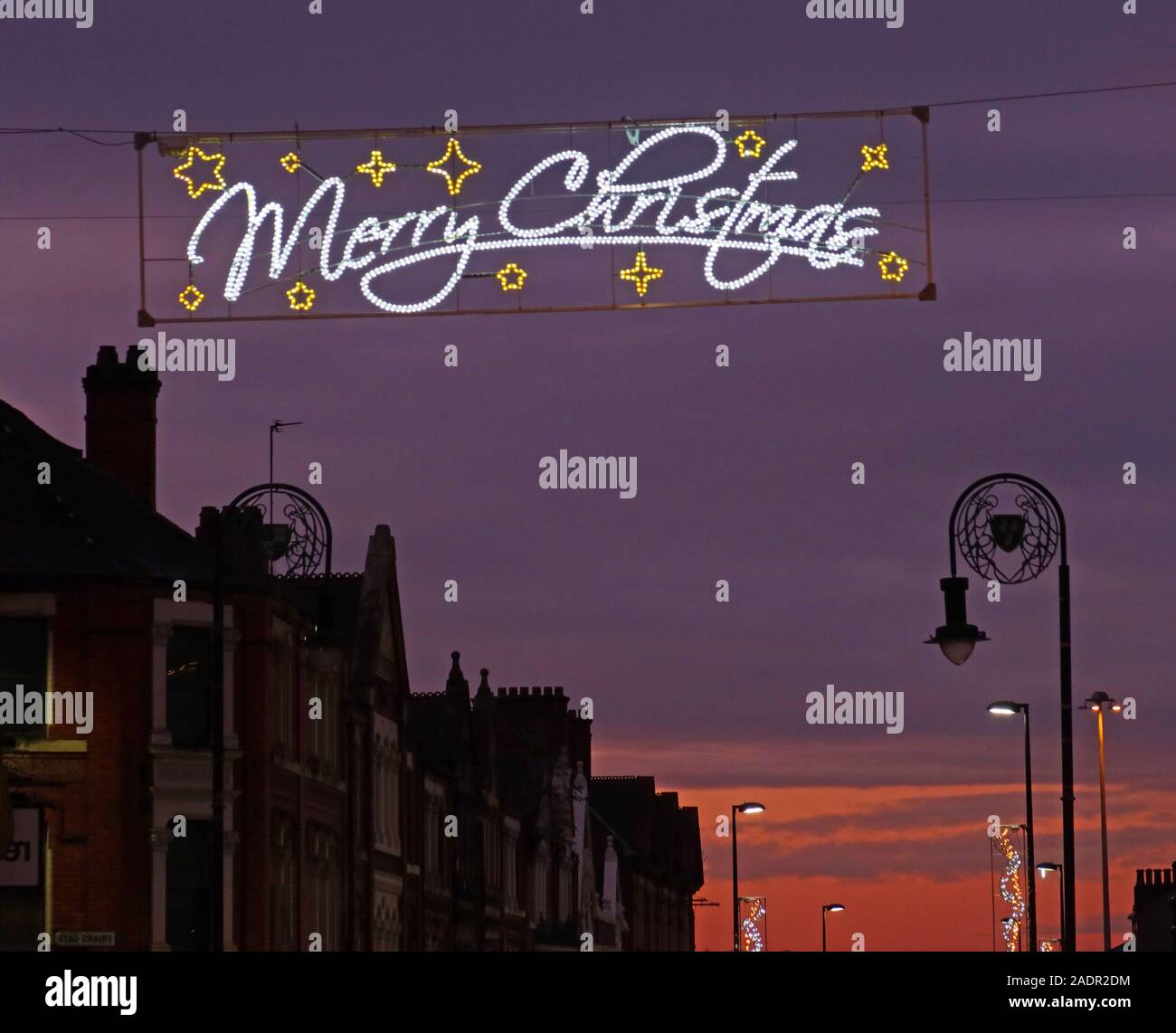 Tramonto su Bridge Street Warrington, con banner natalizio Merry, Cheshire, Inghilterra, Regno Unito, WA1 2QW Foto Stock