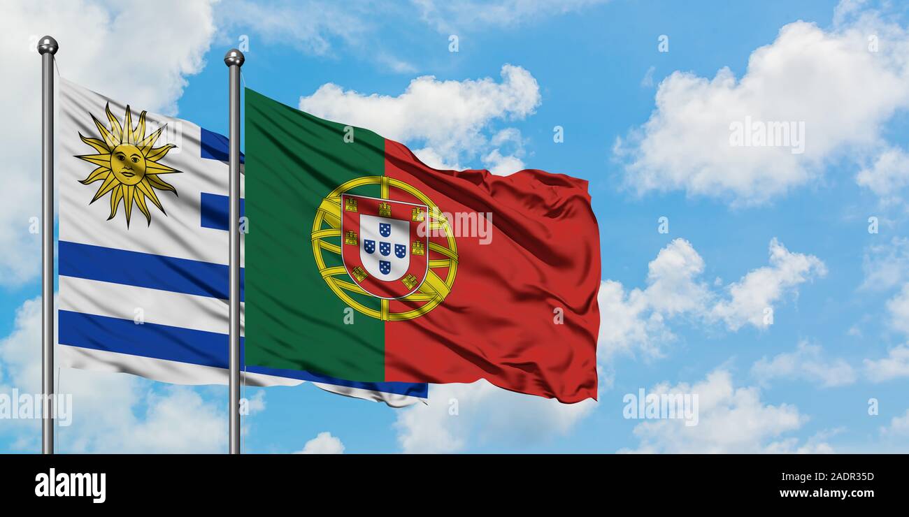 Uruguay e Portogallo bandiera sventolare nel vento contro bianco torbido cielo blu insieme. Concetto di Diplomazia e relazioni internazionali. Foto Stock