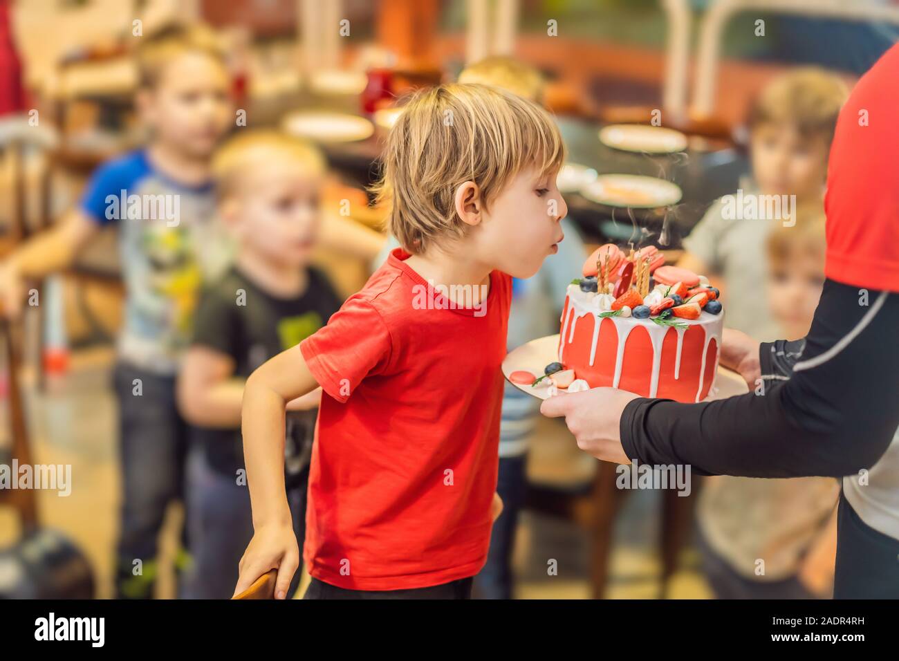 Tempo di soffiare le candele a un bambino festa di compleanno. 6 anno vecchio ragazzo si brucia candele sulla torta Foto Stock