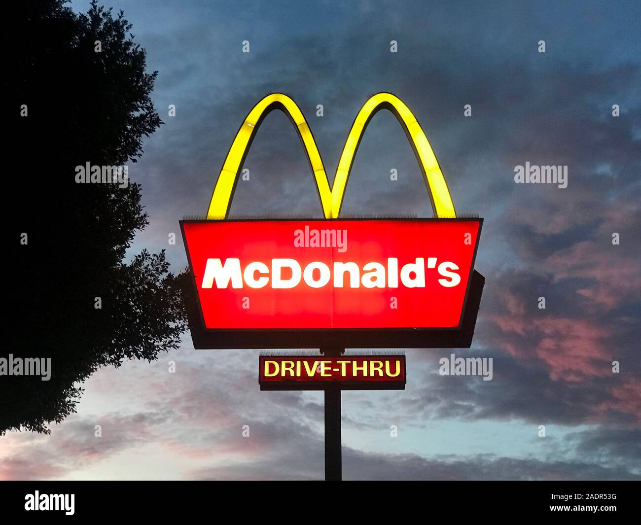 McDonald's sign illuminato contro il tramonto colorato a Los Angeles, CA, Stati Uniti d'America Foto Stock
