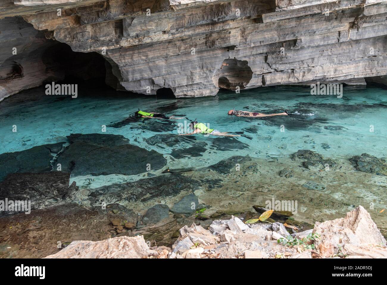 Bella vista a persone snorkeling interno naturale blu acqua fiume nella grotta rocciosa, Chapada Diamantina, Bahia, Brasile Foto Stock