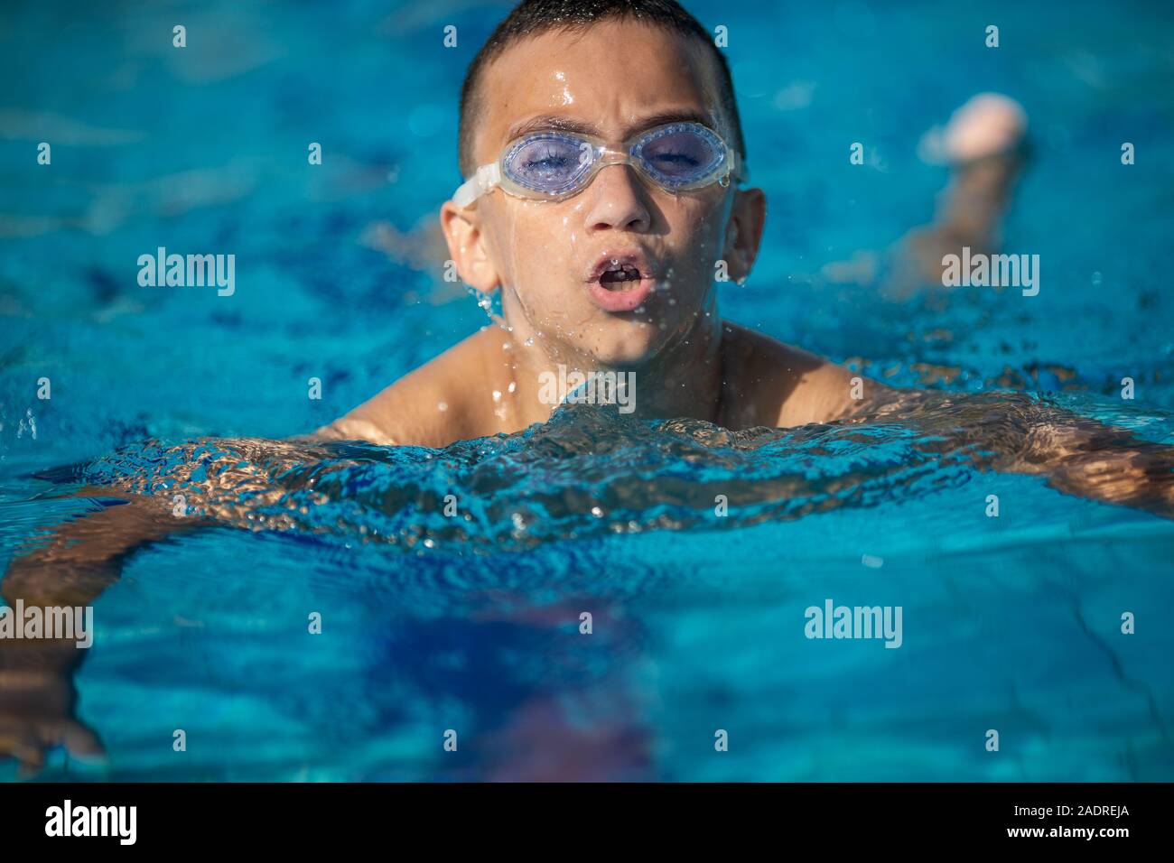 Close-up del ragazzo con gli occhiali per nuoto, nuoto in piscina Foto Stock