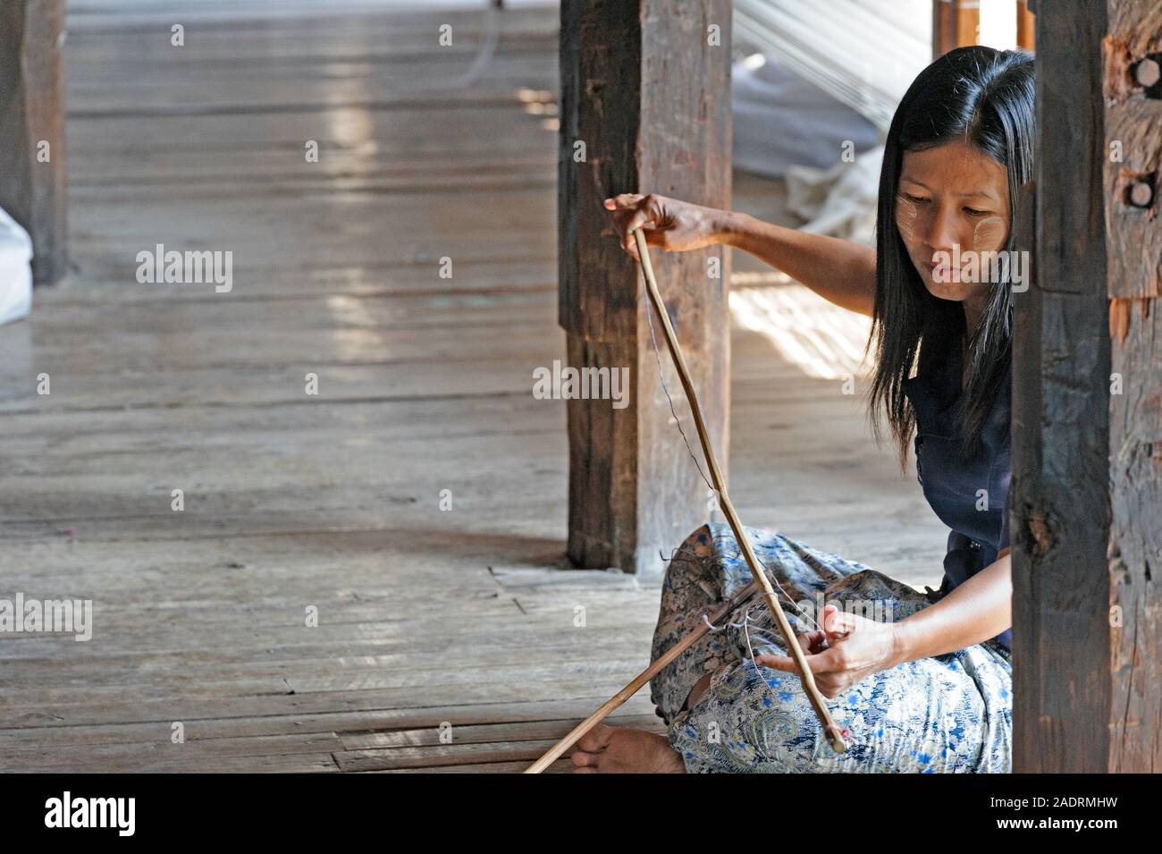 La donna la preparazione di tessuto per l'avvio del processo di tessitura su un telaio di tessitura. Lago Inle, MYANMAR Birmania Foto Stock