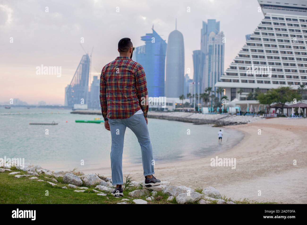 Vista posteriore dell'uomo in piedi sulla spiaggia Foto Stock