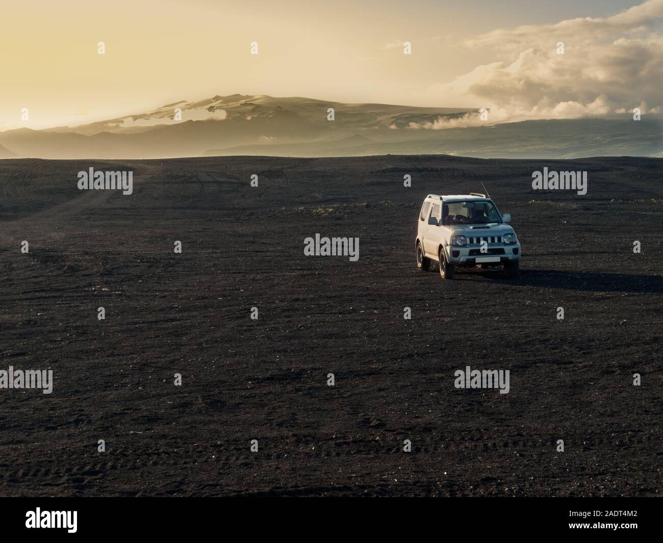Un 4x4 auto in off-road route attraverso l entroterra di Islanda attraverso la ghiaia e strade di pietra con drammatica del cielo. Lava il paesaggio del deserto Foto Stock