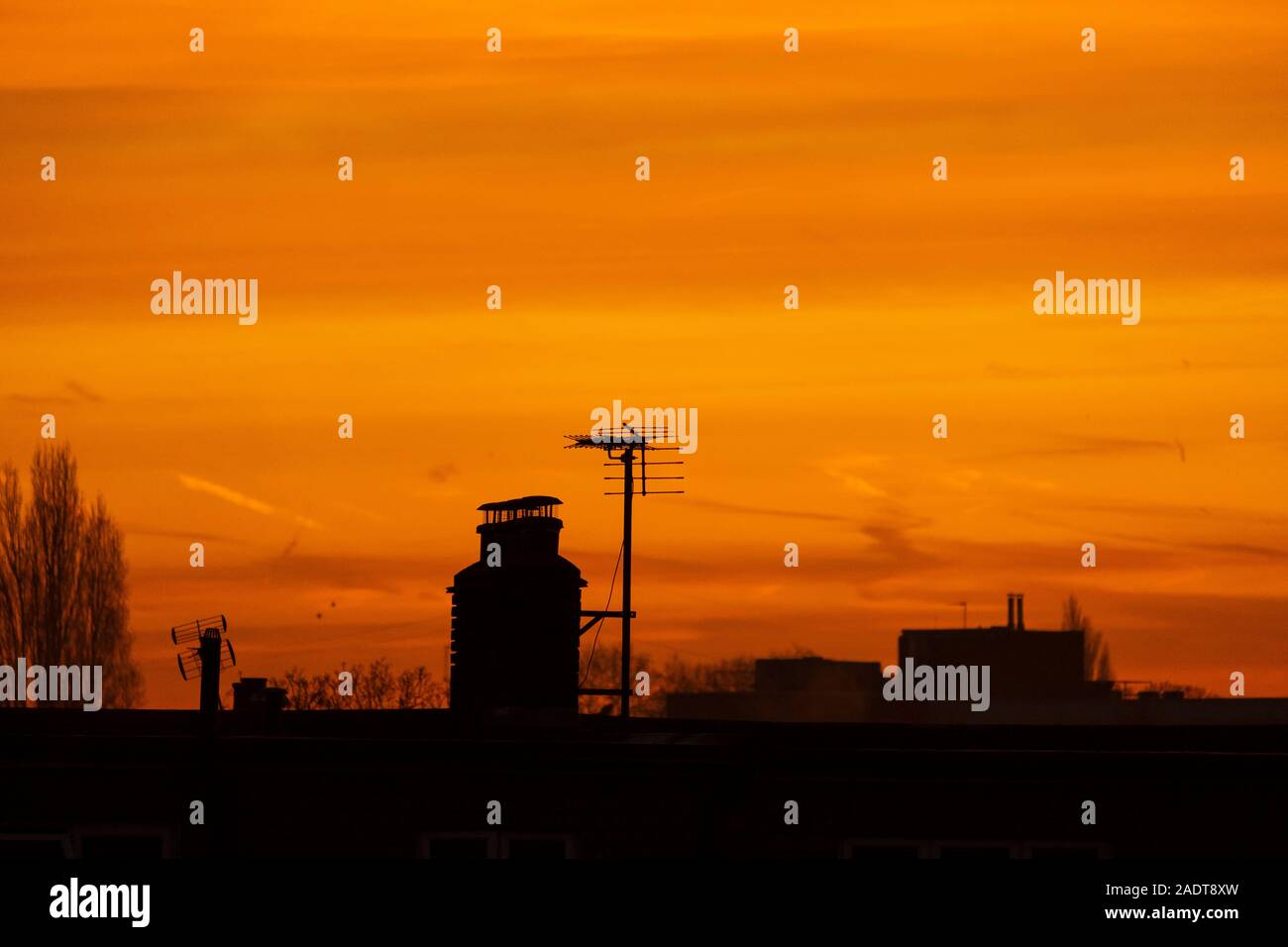 Il torneo di Wimbledon, Londra, Regno Unito. Il 5 dicembre 2019. Vivido arancione sunrise suburbana sopra il sud ovest di Londra dopo un nebbioso e gelido di notte. Credito: Malcolm Park/Alamy Live News. Foto Stock