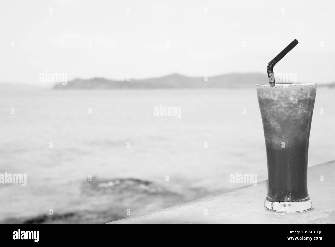 Rinfrescante frullato di anguria contro la vista della spiaggia Foto Stock