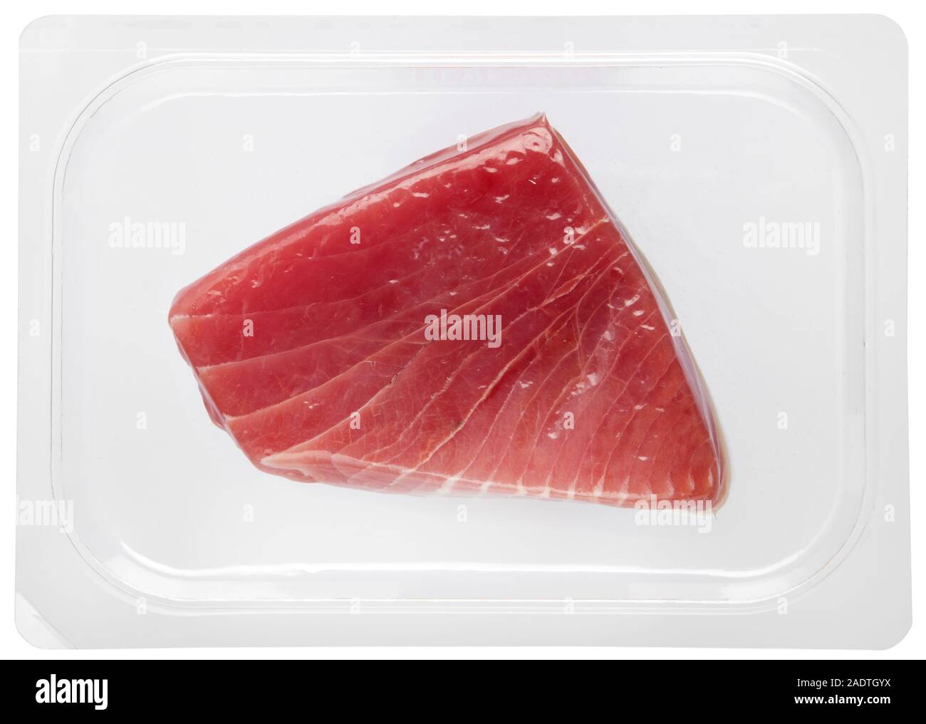 Fresco e salutare bistecca di tonno confezionato sotto vuoto in plastica su uno sfondo bianco in una vista ravvicinata in un cibo e concetto di nutrizione Foto Stock