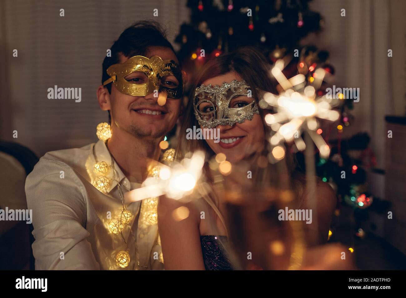 Natale e Anno Nuovo concetto di partito. Matura in amore ardente botti da illuminato albero di Natale con champagne. Foto Stock