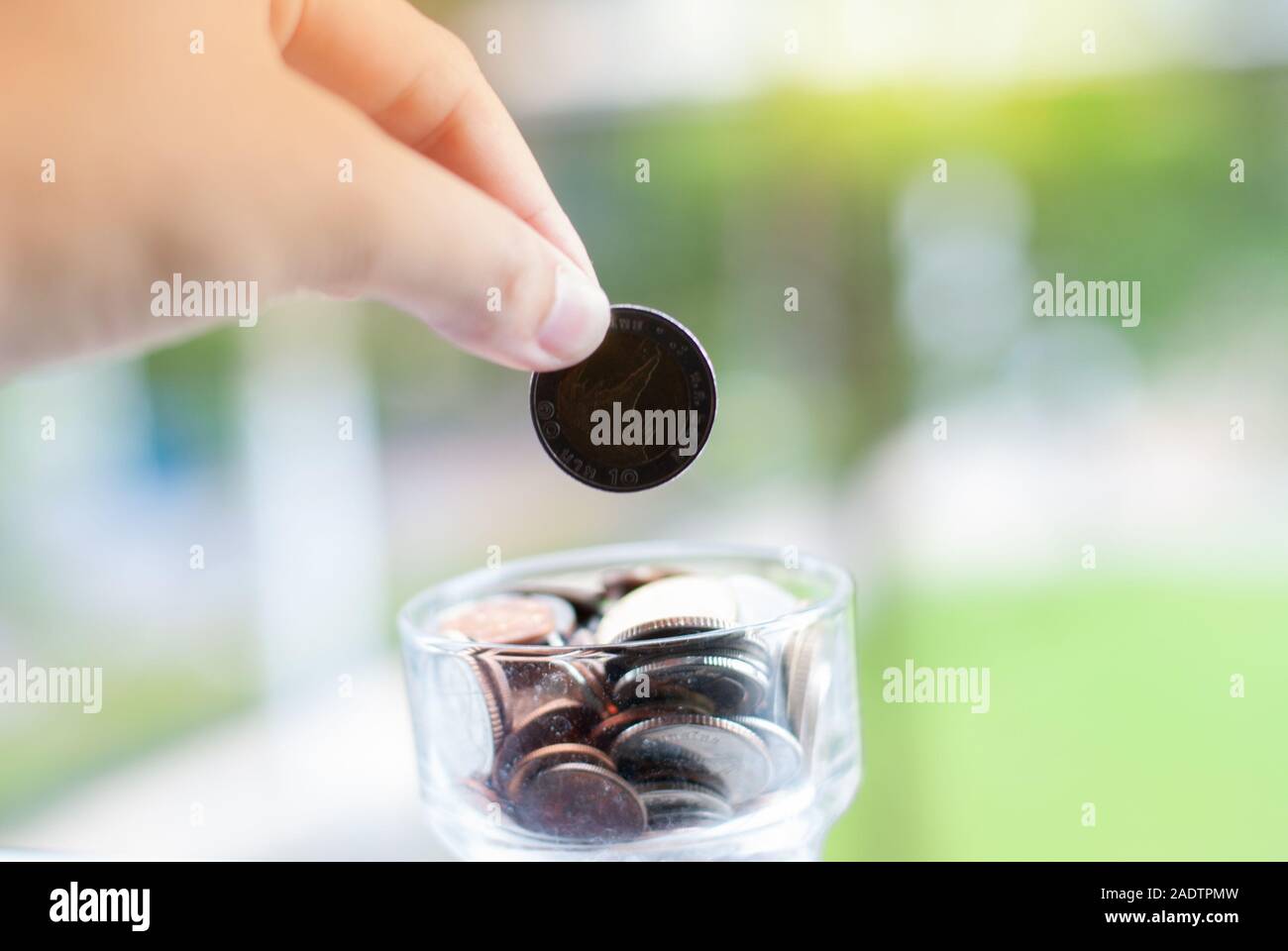 Monete che cadono nella giara - risparmio di denaro Foto Stock