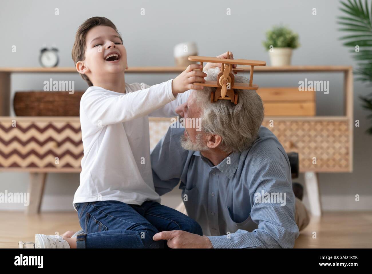 Piccolo NIPOTE nonno e giocare insieme con elicottero giocattolo di legno Foto Stock