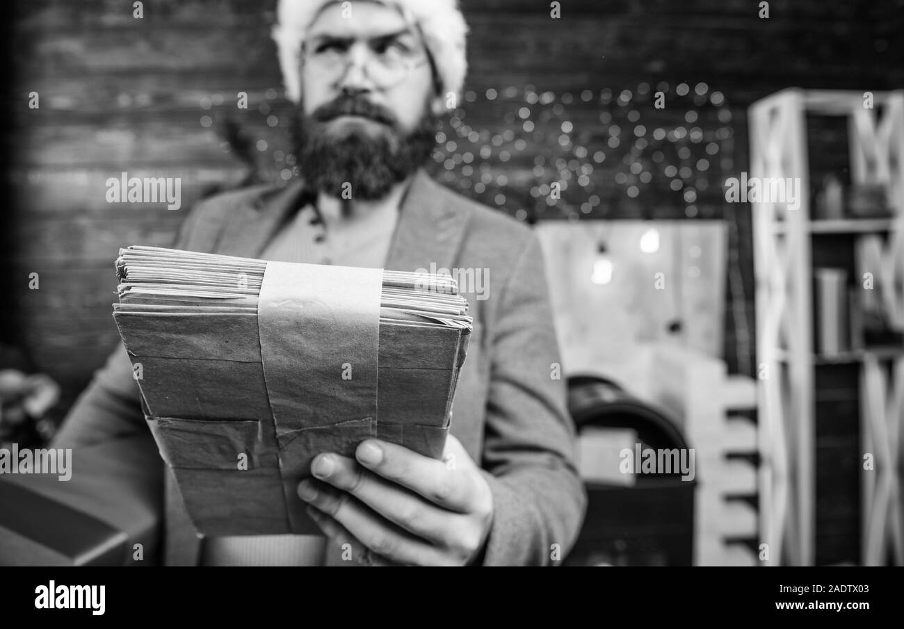 Uomo Barbuto hipster usura santa hat tenere mazzetto di lettere e confezione regalo. Lettera a Babbo Natale. Uomo Barbuto maturo con occhiali ricevuto post per santa. Doni di servizio di consegna. Post per babbo natale. Foto Stock
