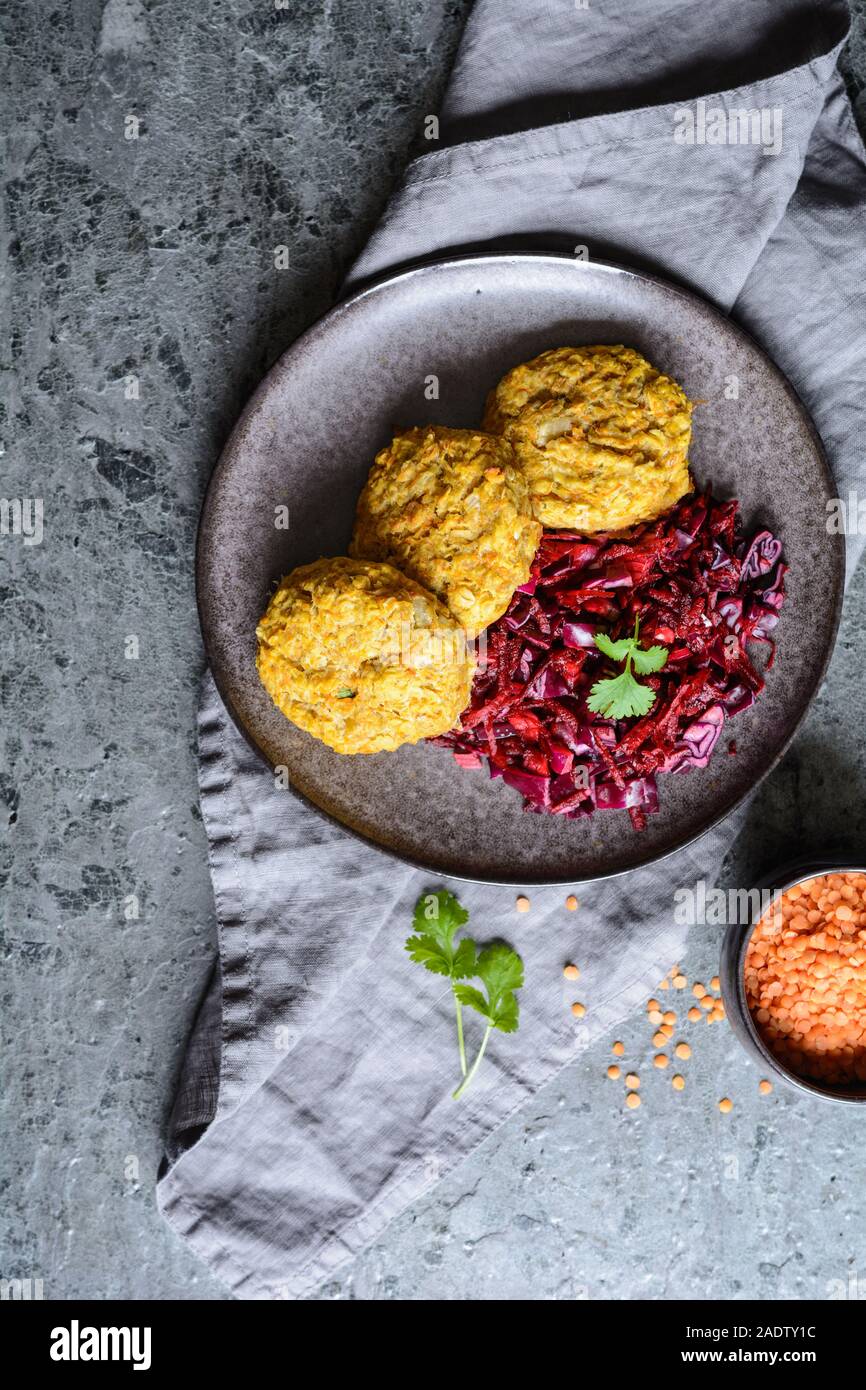 Sana le frittelle fatte dal di lenticchie rosse, carota e i fiocchi d'avena servite con cipolla rossa e cavolo Foto Stock
