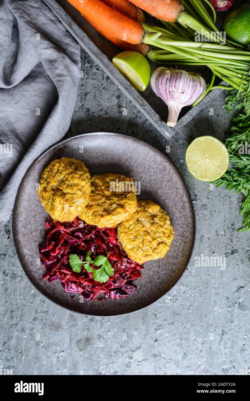 Sana le frittelle fatte dal di lenticchie rosse, carota e i fiocchi d'avena servite con cipolla rossa e cavolo Foto Stock