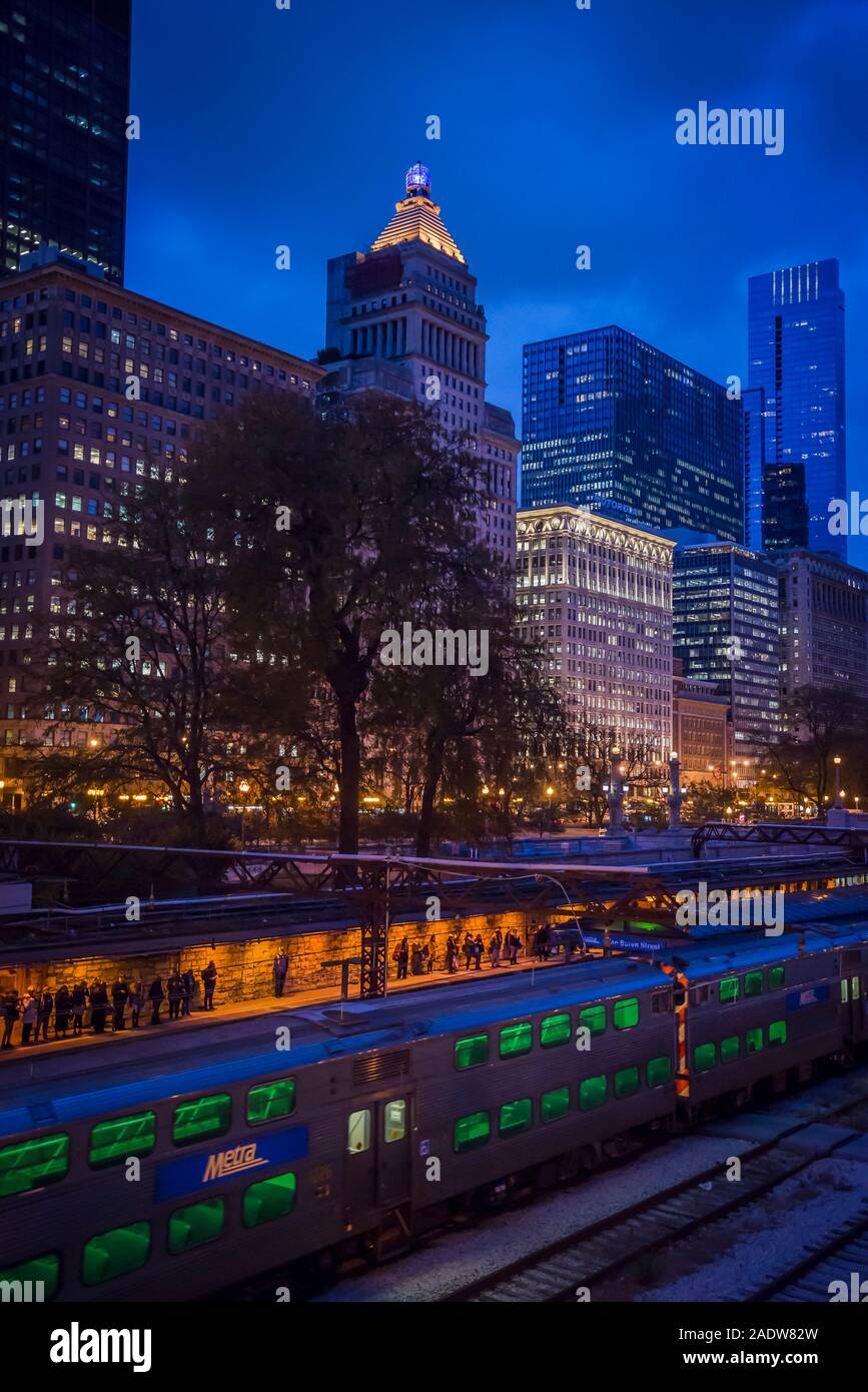 Skyline della città di grattacieli illuminati lungo South Michigan Ave, nel centro cittadino di Chicago Loop area e le linee ferroviarie e le persone in attesa di treno, Chicag Foto Stock