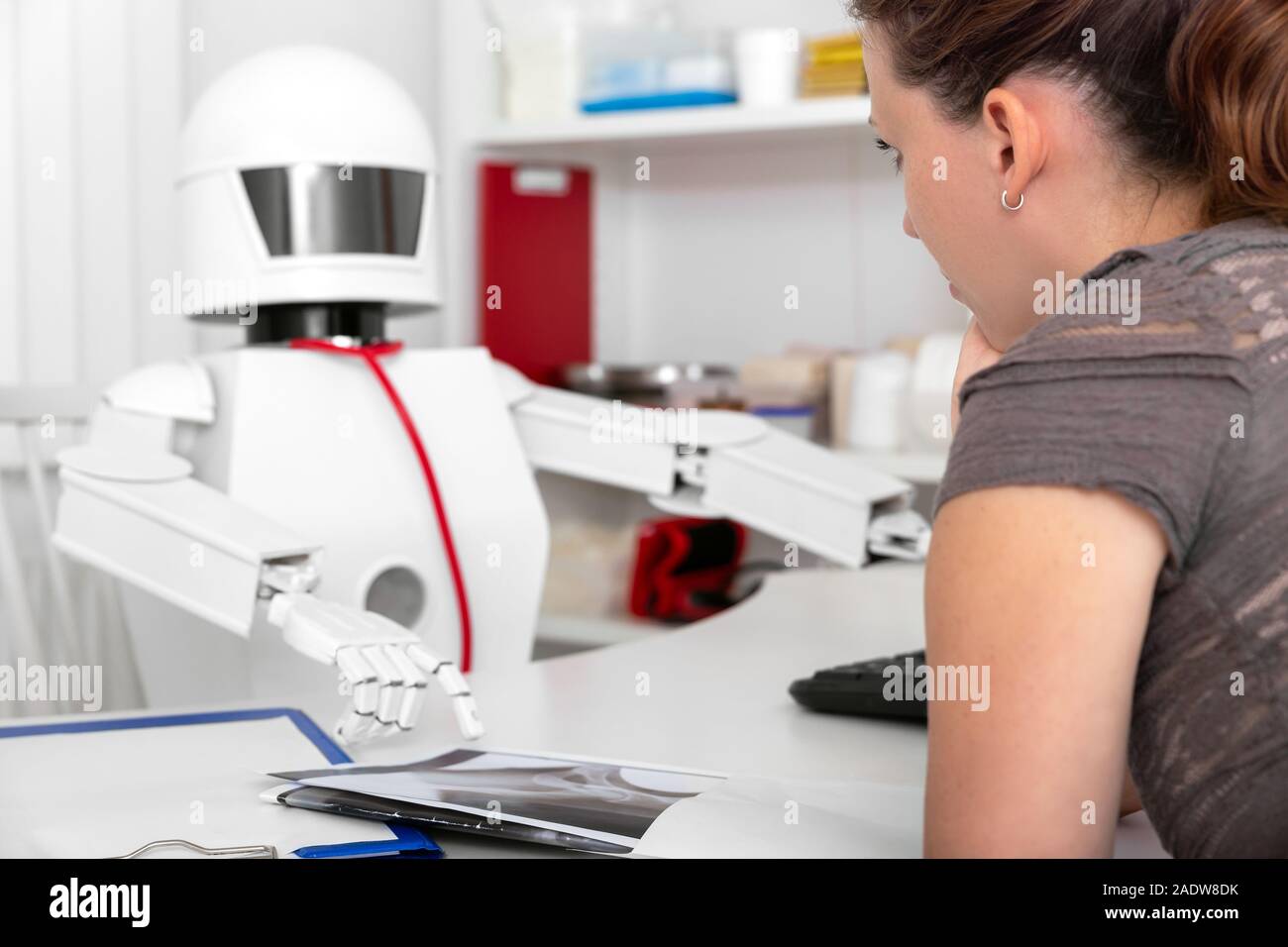 Paziente femmina consultating è una medicina ai robot nel suo ufficio, il concetto della mancanza di professionisti Foto Stock