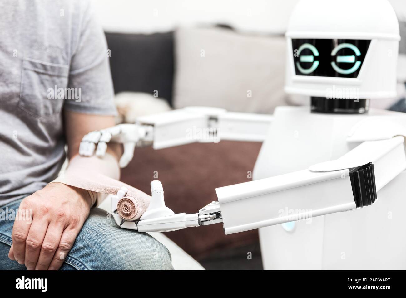 Assistenza Servizio di medicina robot è mettere un cerotto su un braccio di un paziente di sesso maschile, a casa in camera da letto Foto Stock