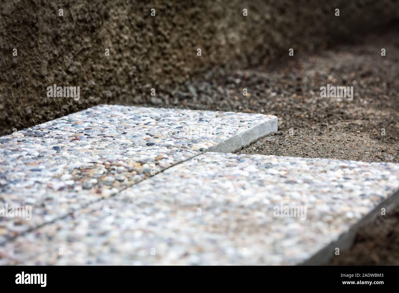 Fresca di cui lavato le lastre di cemento nell'area esterna, solette nel letto di ghiaia Foto Stock