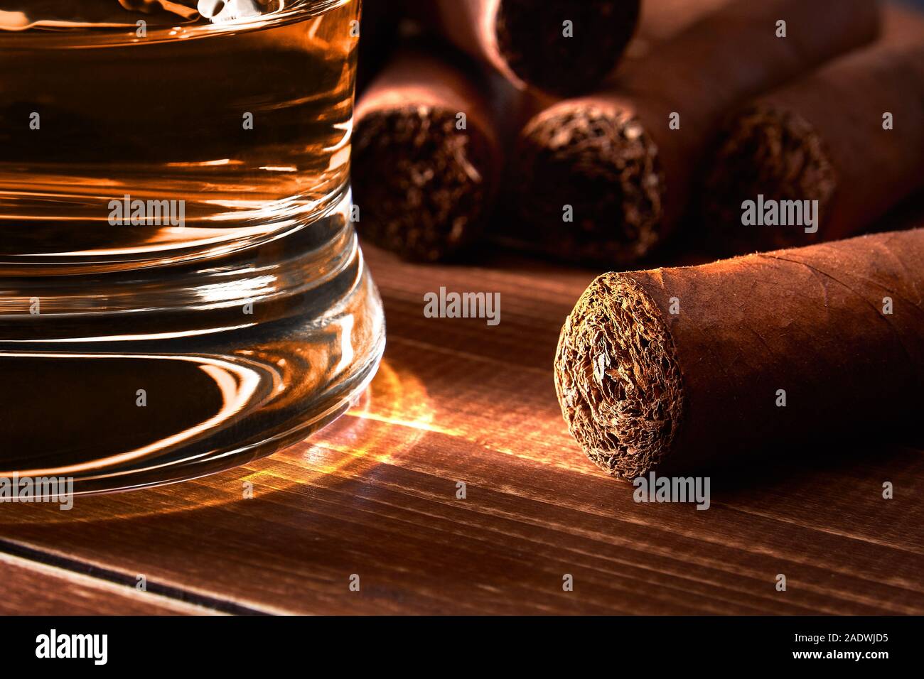 Natura morta con un bicchiere di whiskey o rum sigaro su una vecchia tavola di legno tabella. Sfondo sfocato. Foto Stock