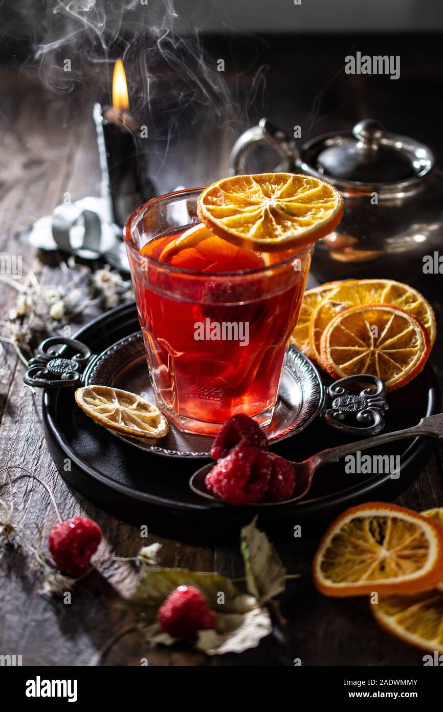 Inverno tè con arance dalla candela.Decorazione di frutta.il cibo sano e bere.tavolo in legno Foto Stock