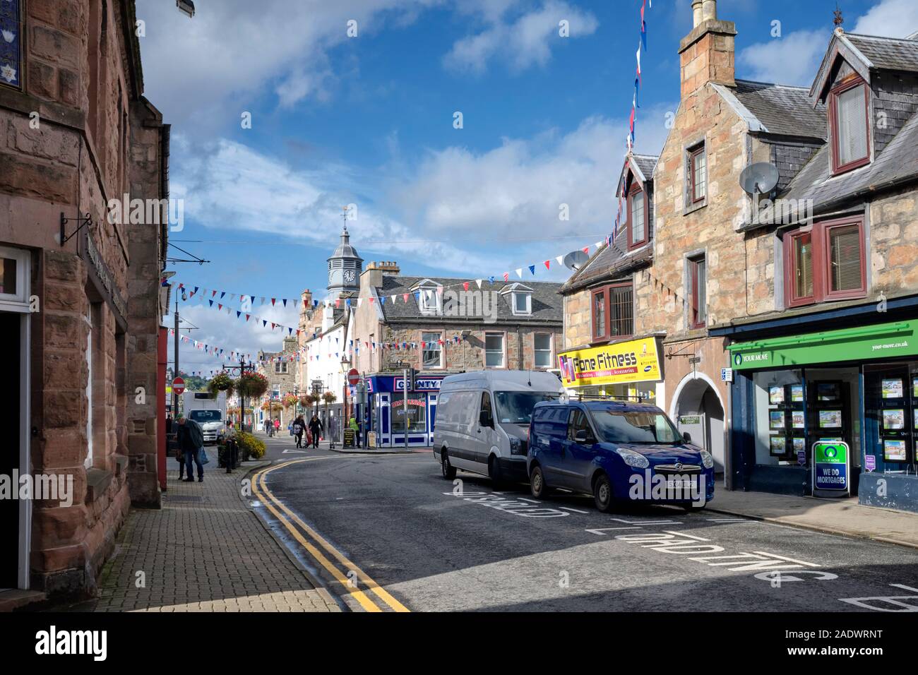 High Street, Dingwall, Ross and Cromarty, Scotland, Regno Unito. 26/09/19 una movimentata vista della strada principale con negozi e bunting, furgoni e pedoni Foto Stock