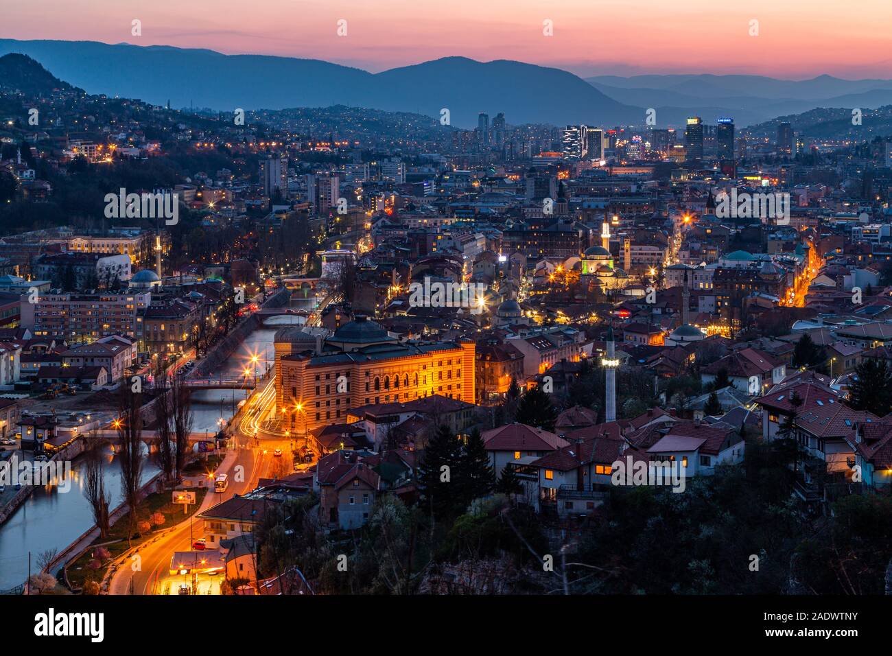 Una antenna di elevata tramonto crepuscolo / Crepuscolo vista di Sarajevo, capitale della Bosnia ed Erzegovina circondata dalle Alpi Dinariche e il fiume Miljacka in vista Foto Stock