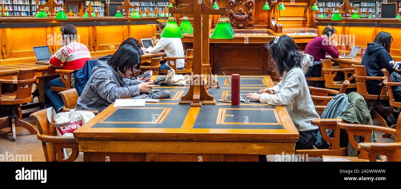 Tavoli in legno pieno di studenti che studiano in La Trobe Sala Lettura della Biblioteca di Stato di Melbourne Victoria Australia. Foto Stock