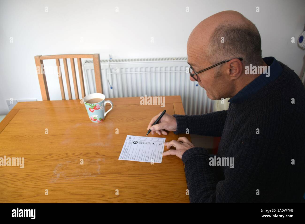 Uomo di completare il suo voto postale - Elezioni generali Dicembre 2019 UK. Signor Foto Stock