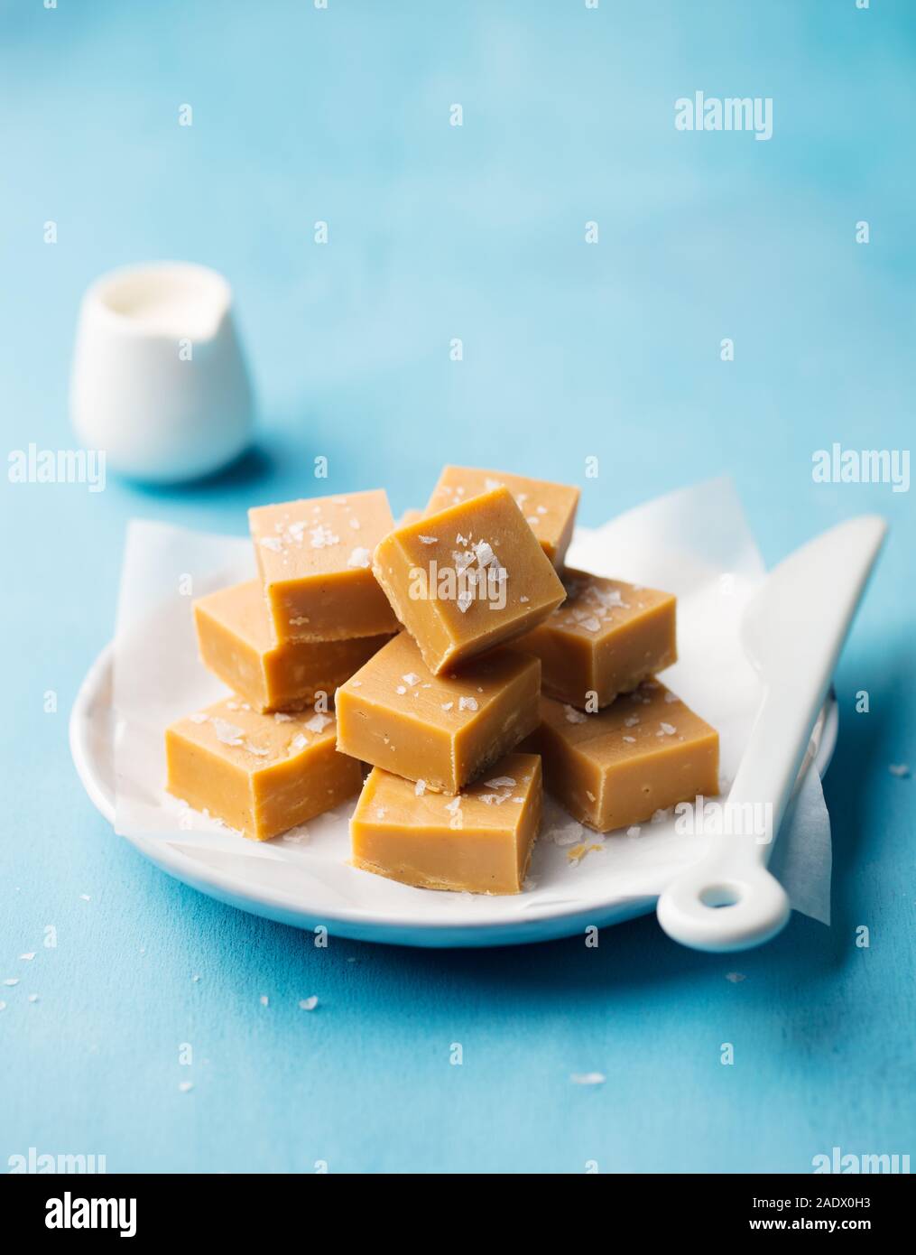Caramello fresco fudge caramelle su una piastra. Sfondo blu. Spazio di copia Foto Stock