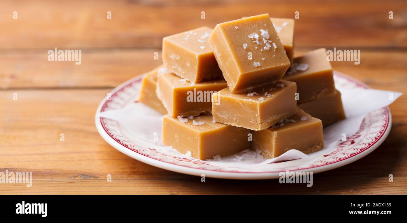 Caramel fudge caramelle su una piastra. Sfondo di legno. Close up Foto Stock