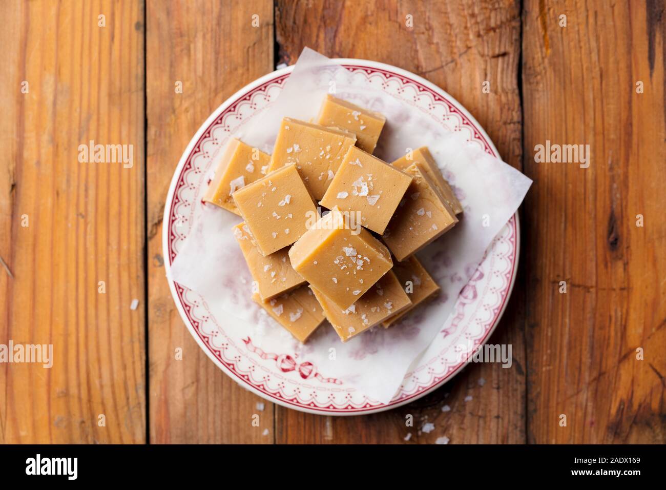 Caramel fudge caramelle su una piastra. Sfondo di legno. Vista superiore Foto Stock