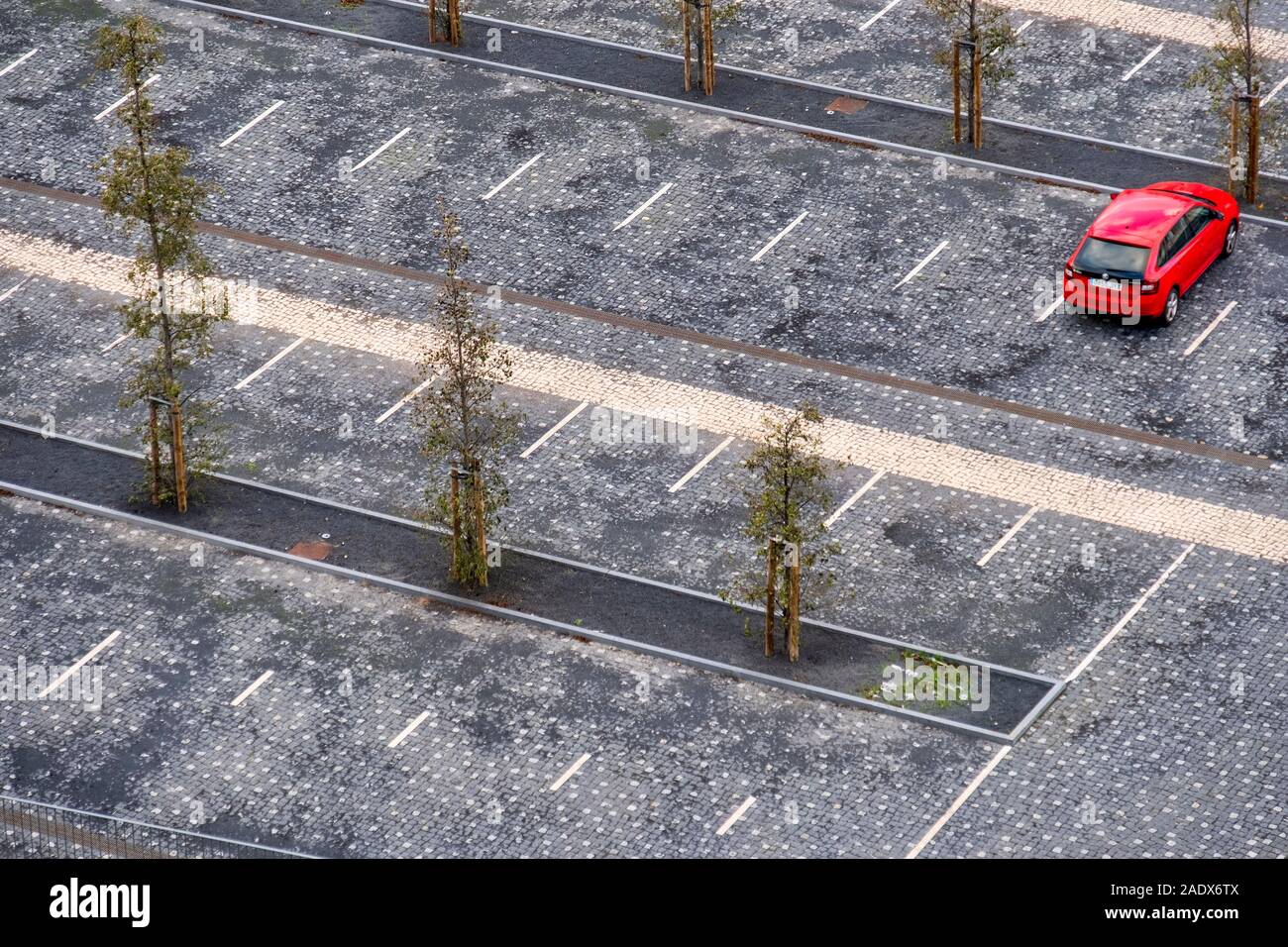 Vista aerea di una singola automobile rossa parcheggiata su un vuoto di parcheggio Foto Stock