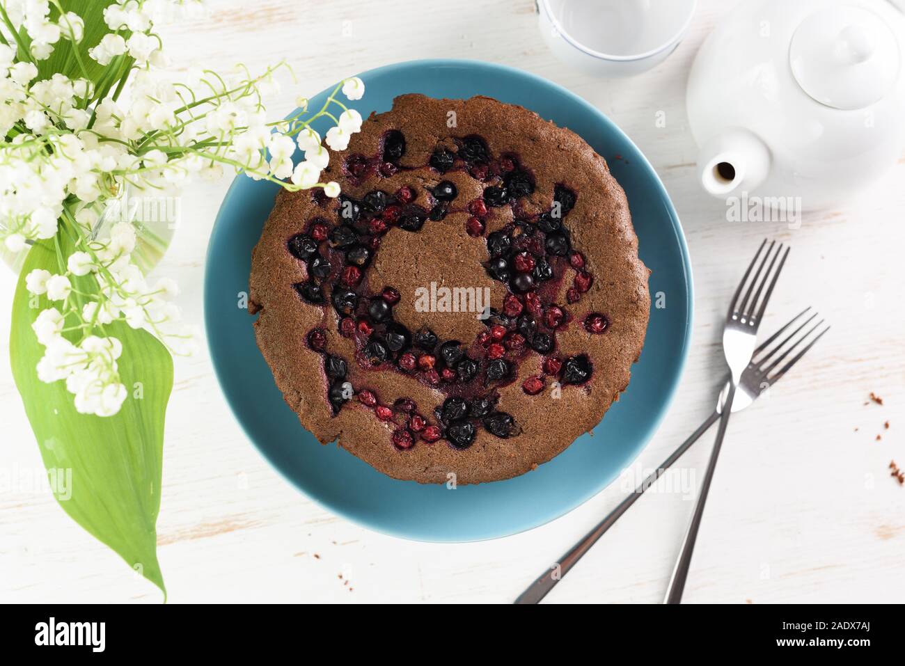 Sana dessert fatti in casa. Siberiano tradizionale torta con bird ciliegia, cowberry e ribes servito con bianco teiera e il giglio della valle flowe Foto Stock