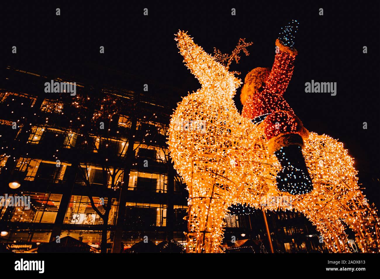 Weihnachtsmann Leuchtender aus Lichterketten reitet auf Rentier im inverno a Berlino Foto Stock