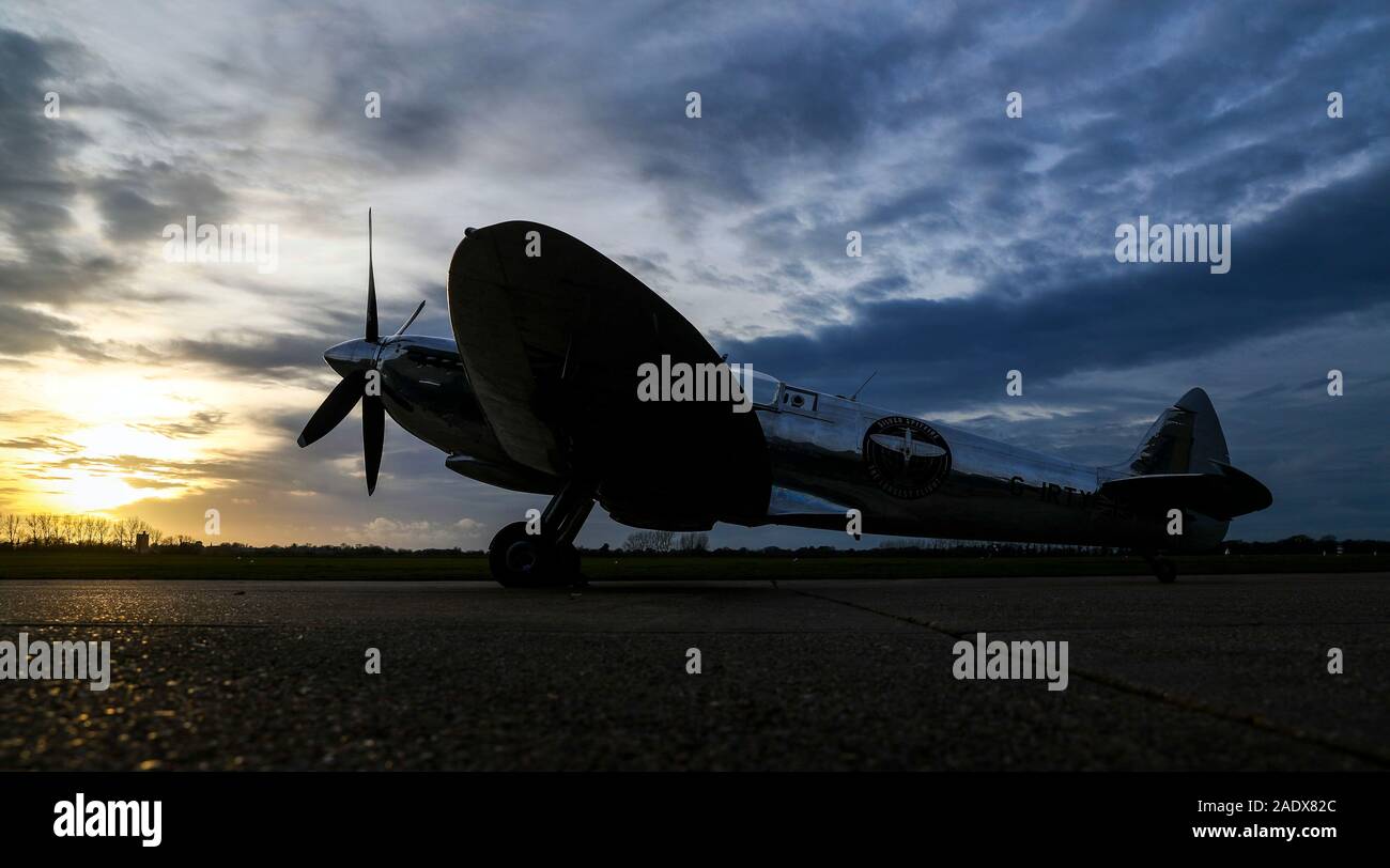 Il sole tramonta oltre la IWC MK IX Argento Spitfire, seguendo il suo atterraggio dal pilota britannico Matt Jones sbarcati a Goodwood Aerodrome dopo che lui ed il compagno di pilota Steve Brooks riesca a circumnavigare il globo nella recentemente restaurata Spitfire. Foto Stock