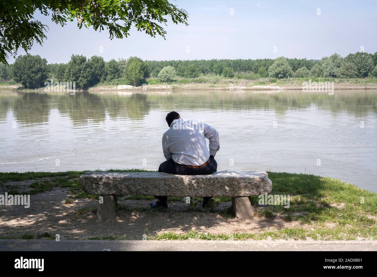 Uomo adulto è in piedi di fronte a un fiume Foto Stock