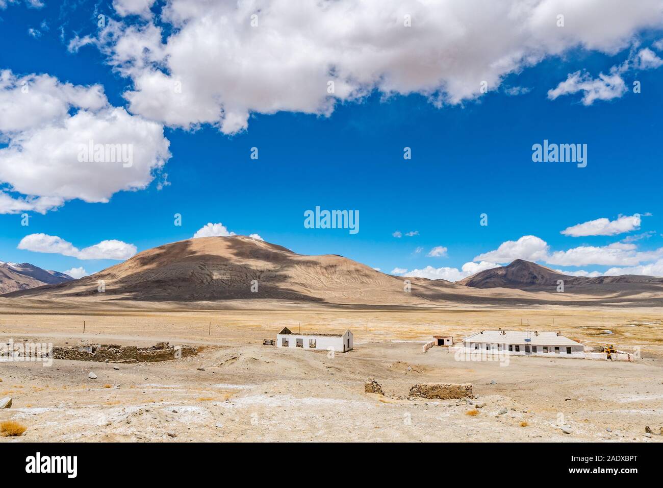 Pamir autostrada M41 edifici con suggestiva vista delle montagne innevate su una soleggiata cielo blu giorno Foto Stock